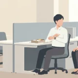 職場のデスクでお弁当を広げる人へ書類を見せる同僚と時間を示す手元